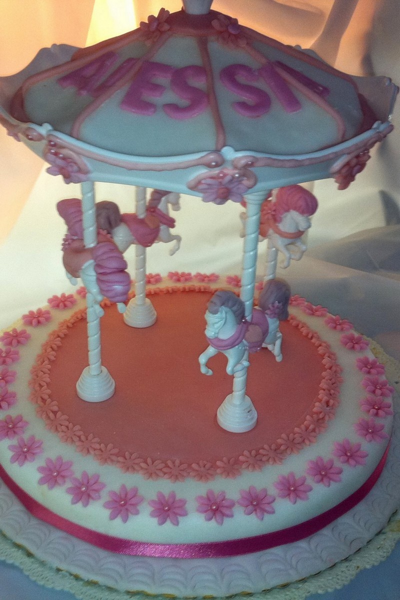 a decorated carousel cake on display in a bakery