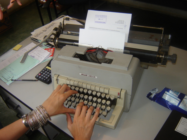 a woman typing on an old style typewriter
