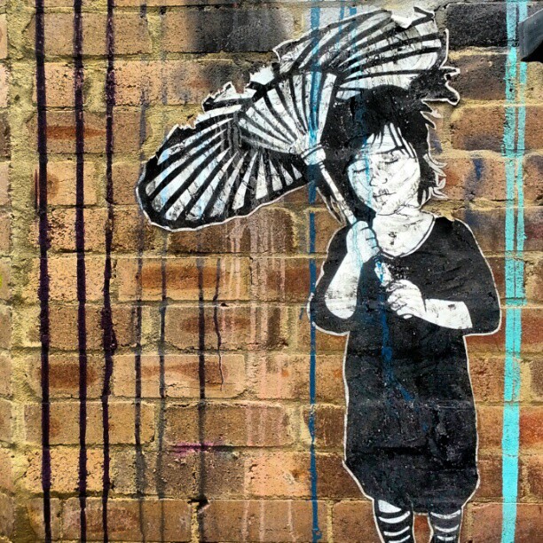 a graffiti painting of a woman holding an umbrella