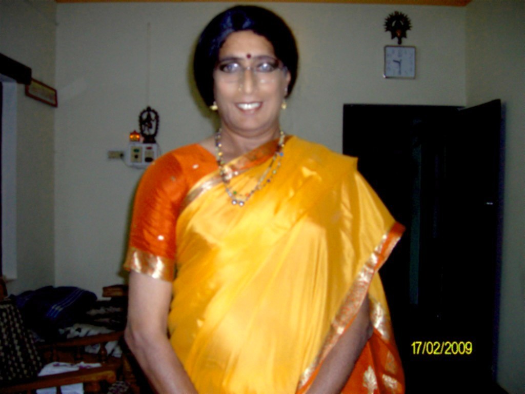 a woman in a sari standing in a kitchen