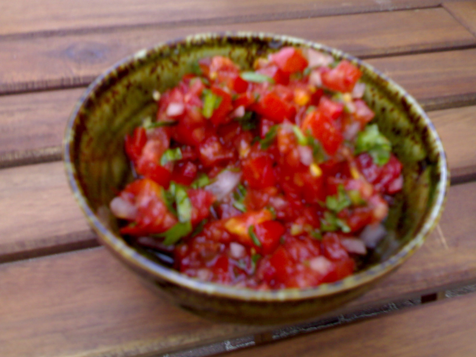 bowl full of chopped tomatoes on wooden table