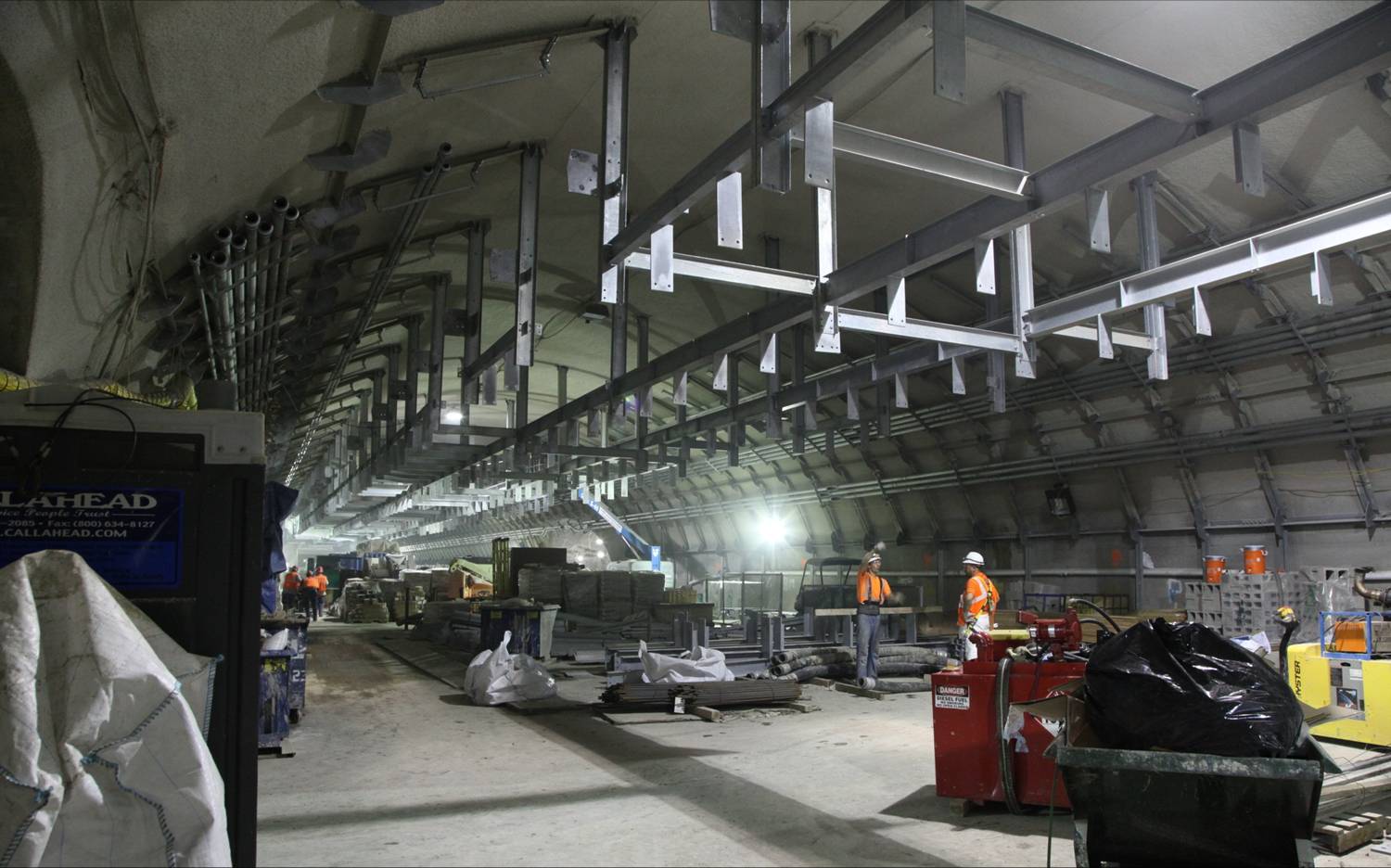 men work in an industrial area with lots of metal equipment