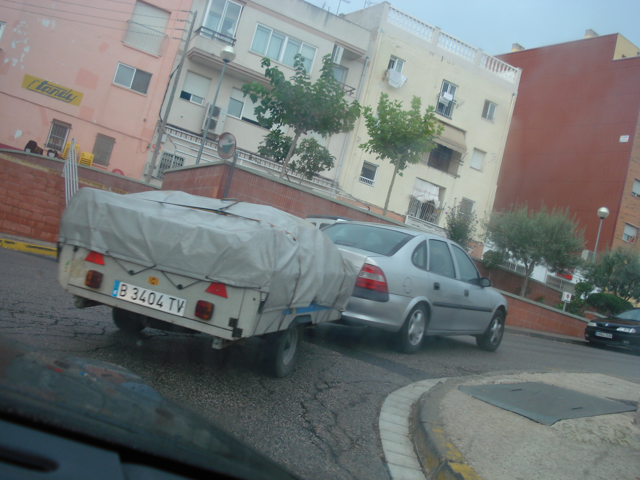 a car and a trailer parked on a street