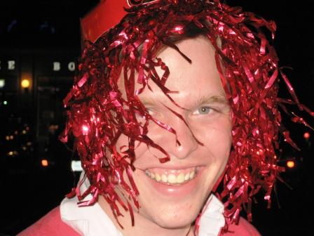 a man is smiling and wearing tinsels on his hair