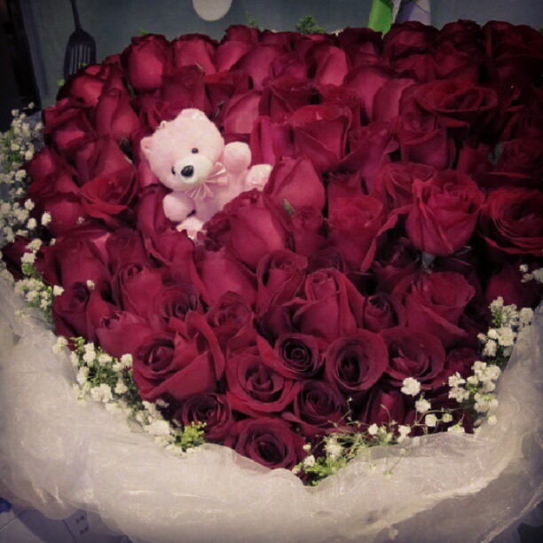 an arrangement of red roses arranged in a heart shaped arrangement