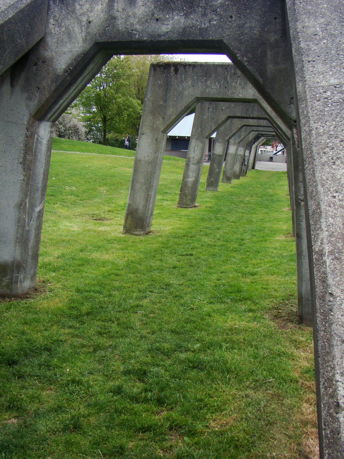 a group of structures on green grass with trees in the background