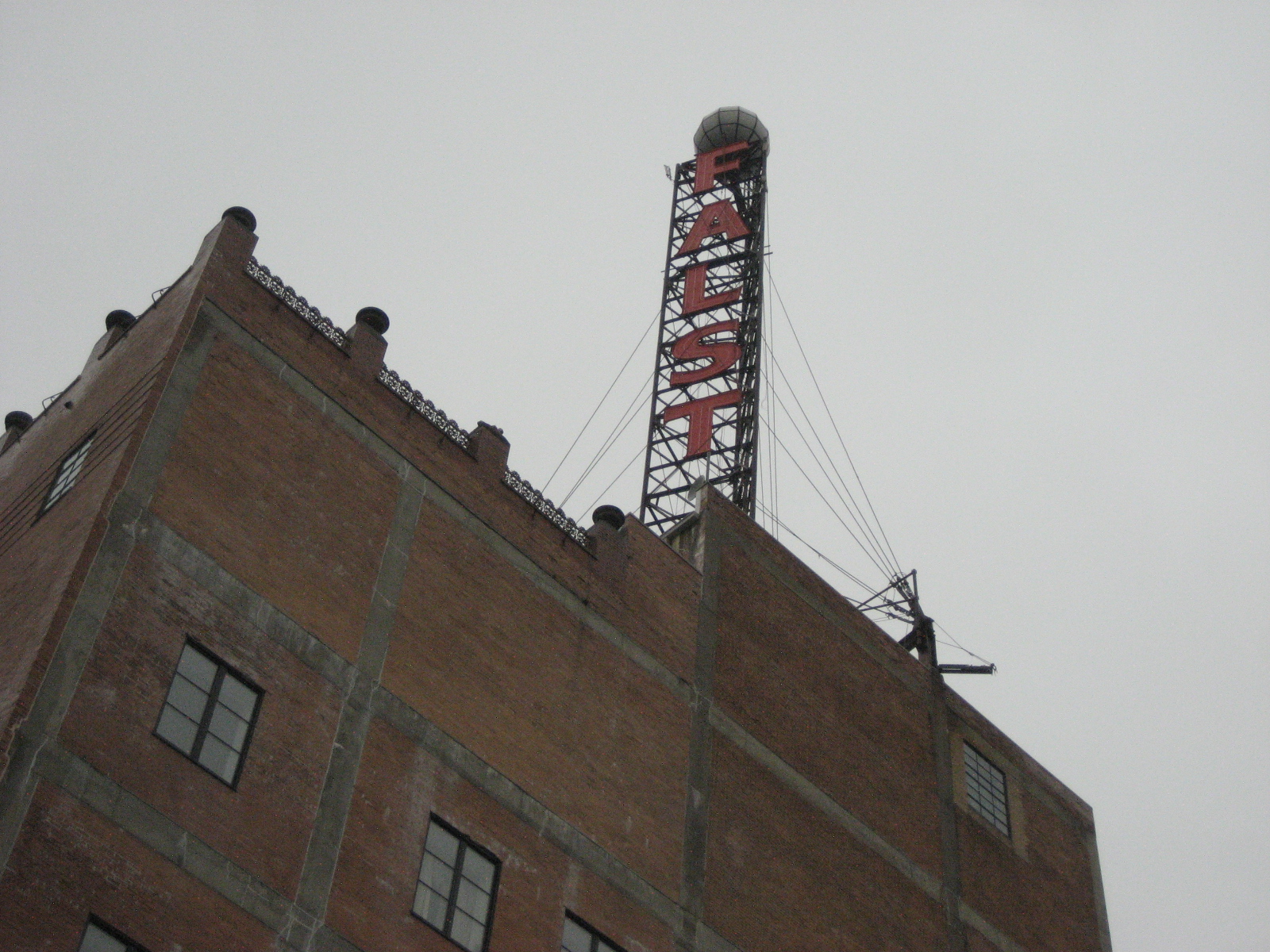 an industrial building with a clock mounted to the side