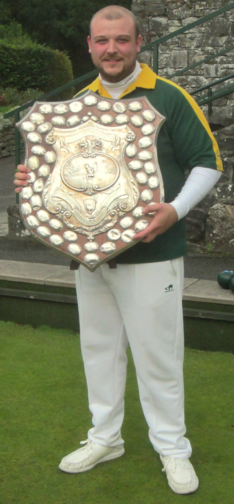 a person with a large metal trophy and posing for a po