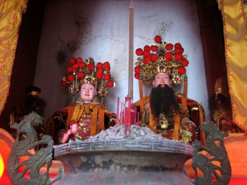 an image of statues with red flowers in a room