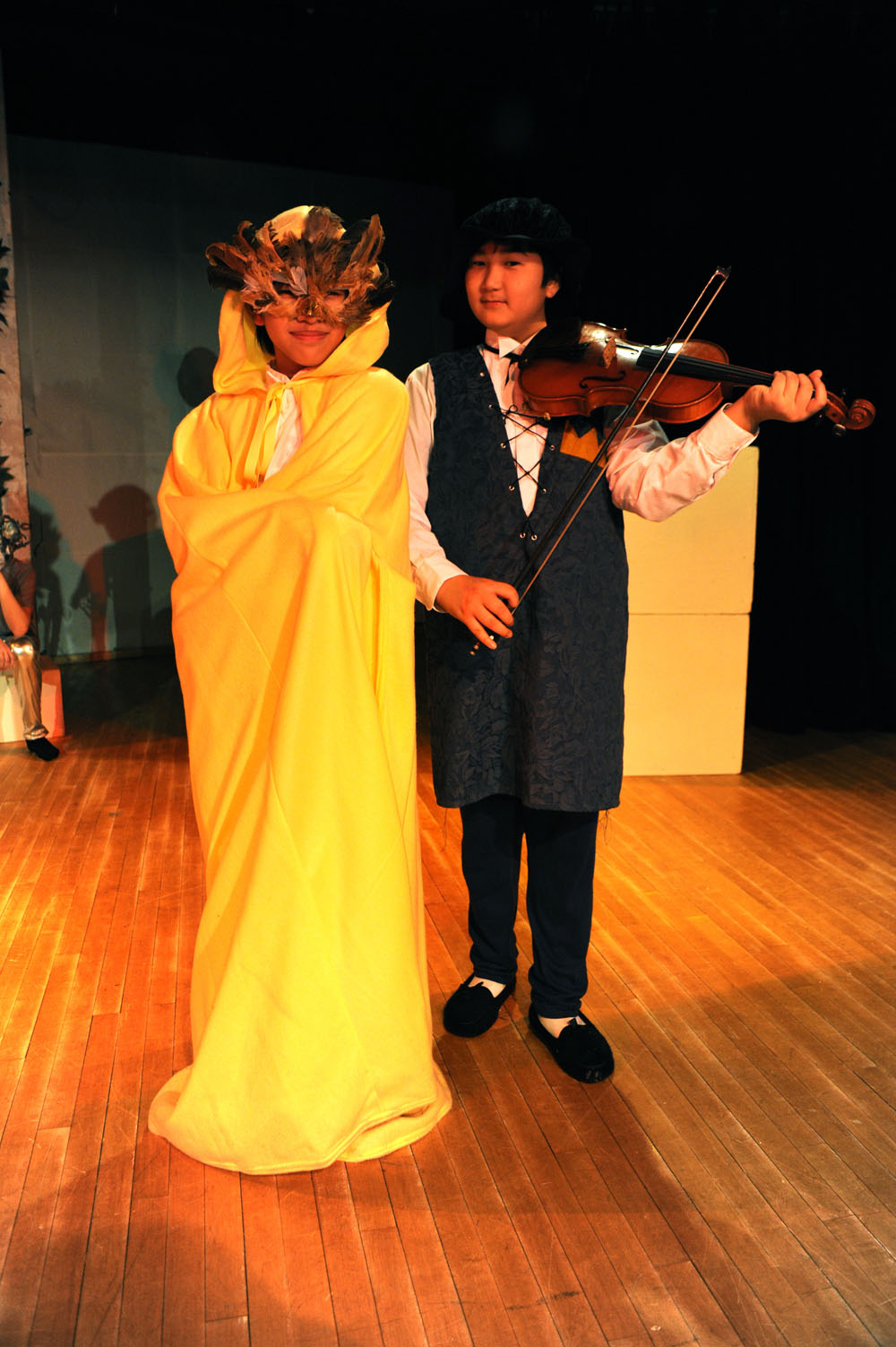 a boy and girl playing the violin together