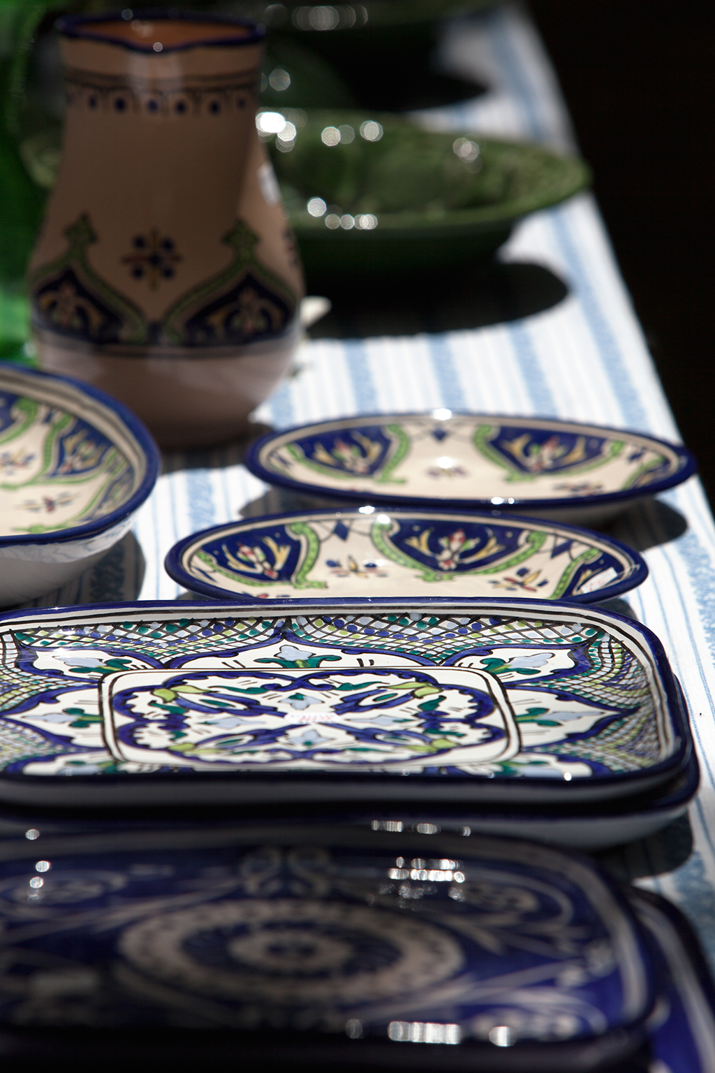 a blue and green table cloth, with fancy plates on it