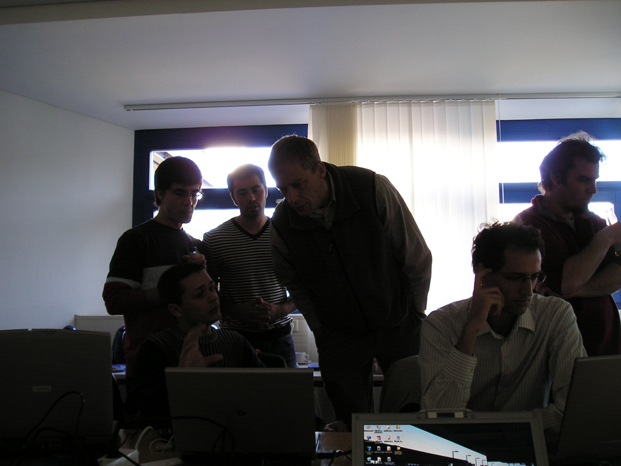 group of men in front of laptops sitting in the same room