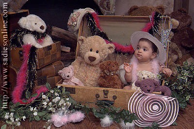 baby in a vintage box surrounded by many teddy bears