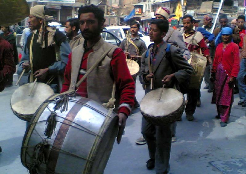 a group of men marching in the street carrying their instruments