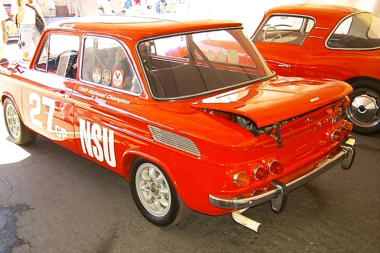 the front of an older race car parked with its hood open