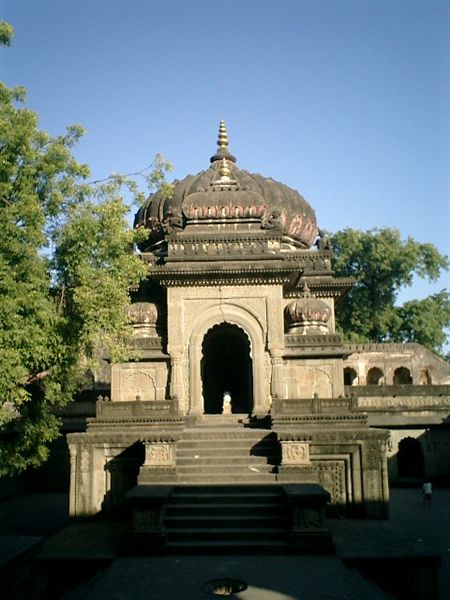 an ornate indian structure is shown against the blue sky