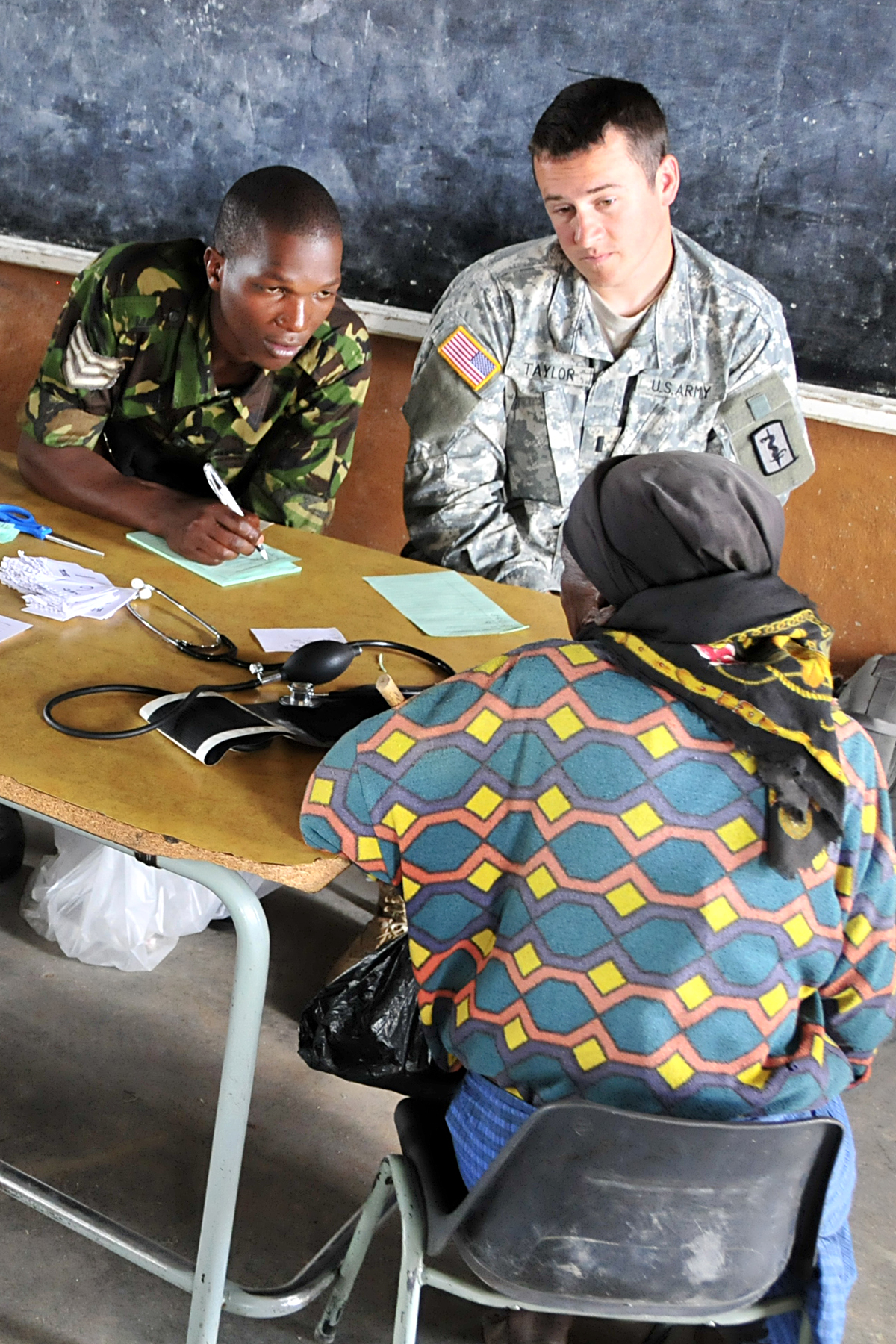 two military men are sitting at a table writing