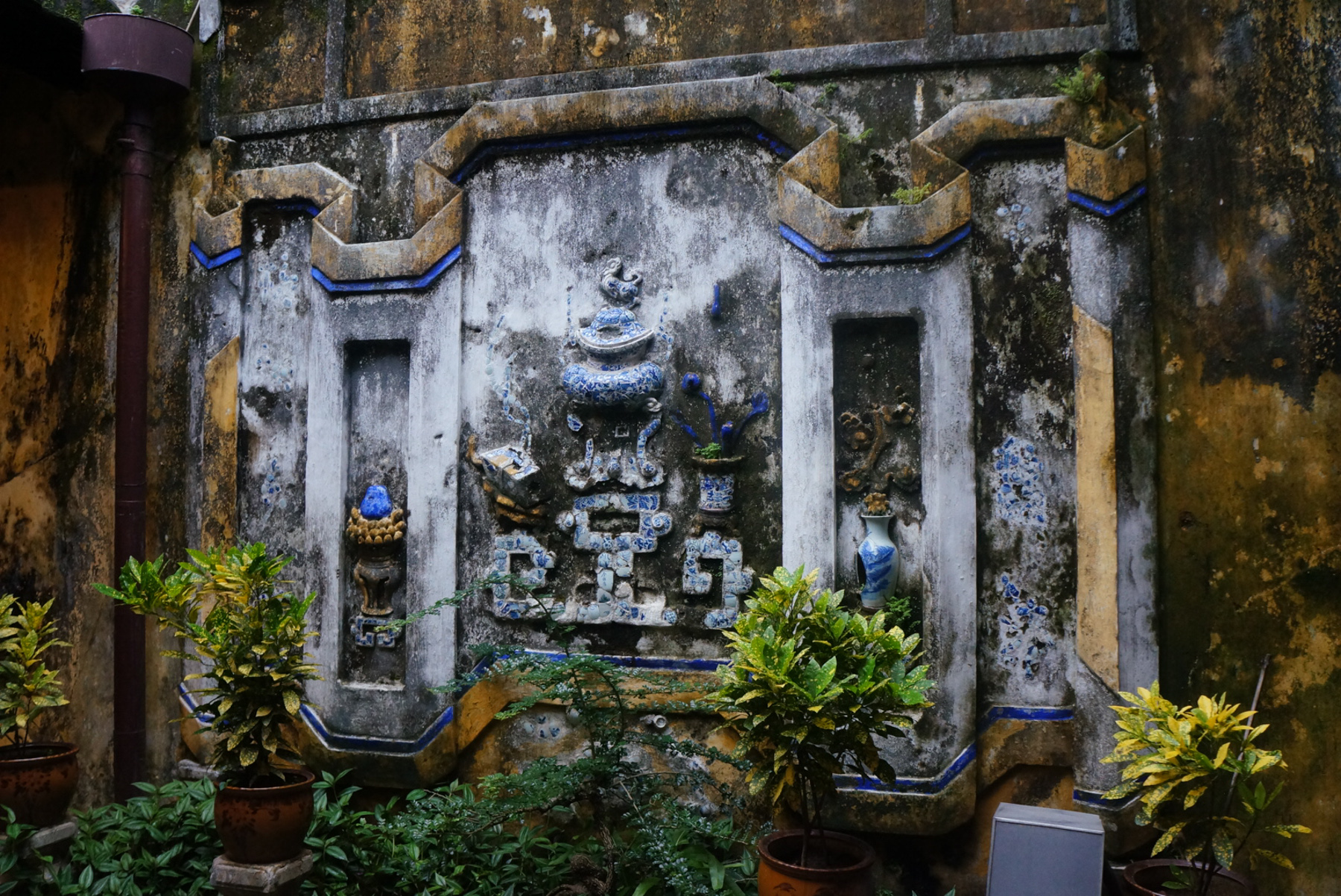 a stone sculpture with several blue vases on it