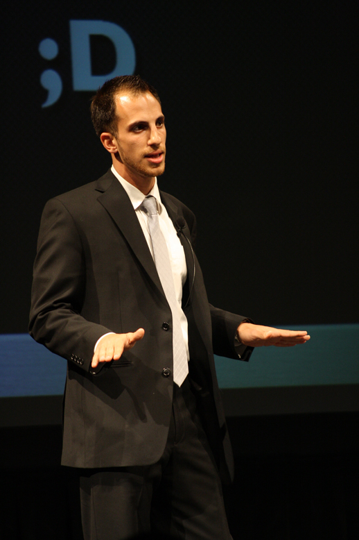 the man in black suit is gesturing while speaking