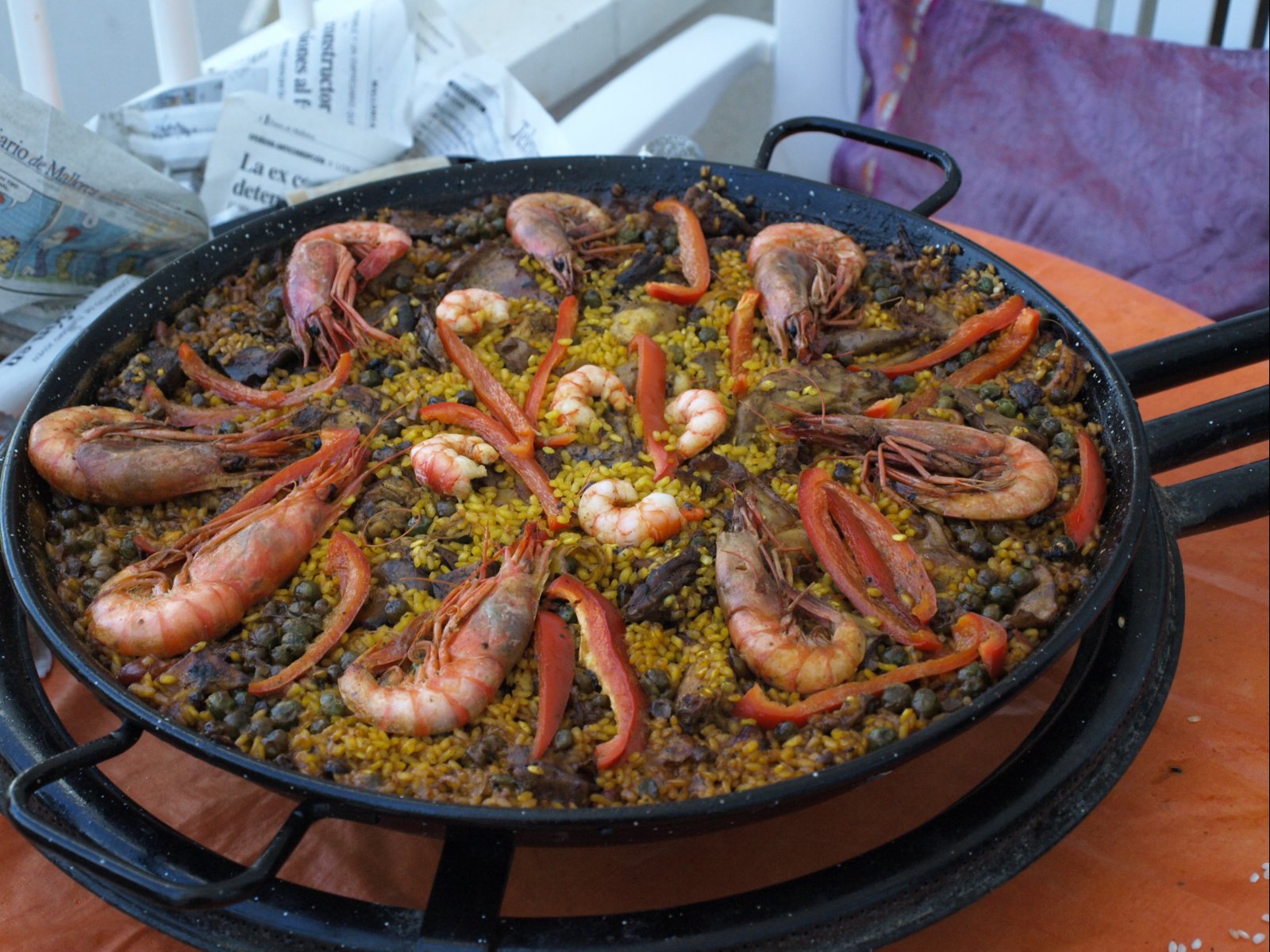 a pan with cooked shrimp and peas sitting on a table