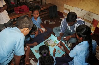 group of people making toys on a blue sheet