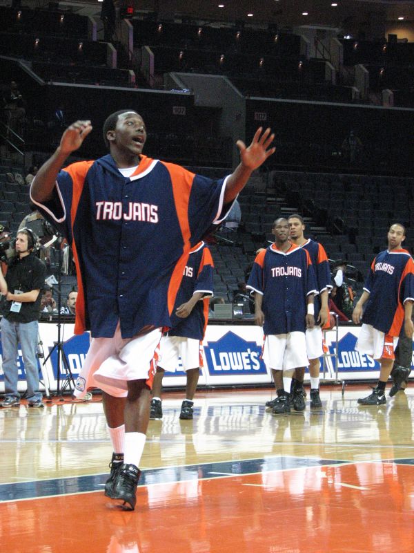 a male basketball player throwing a ball in front of other players