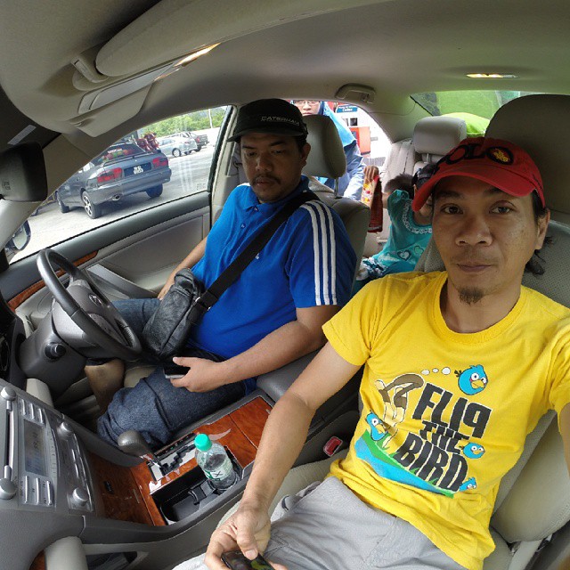 two men sitting in the driver's seat of a car