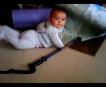 a toddler lays on the floor holding an umbrella