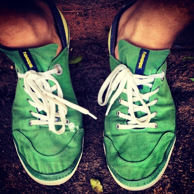 man's feet with white and green shoes