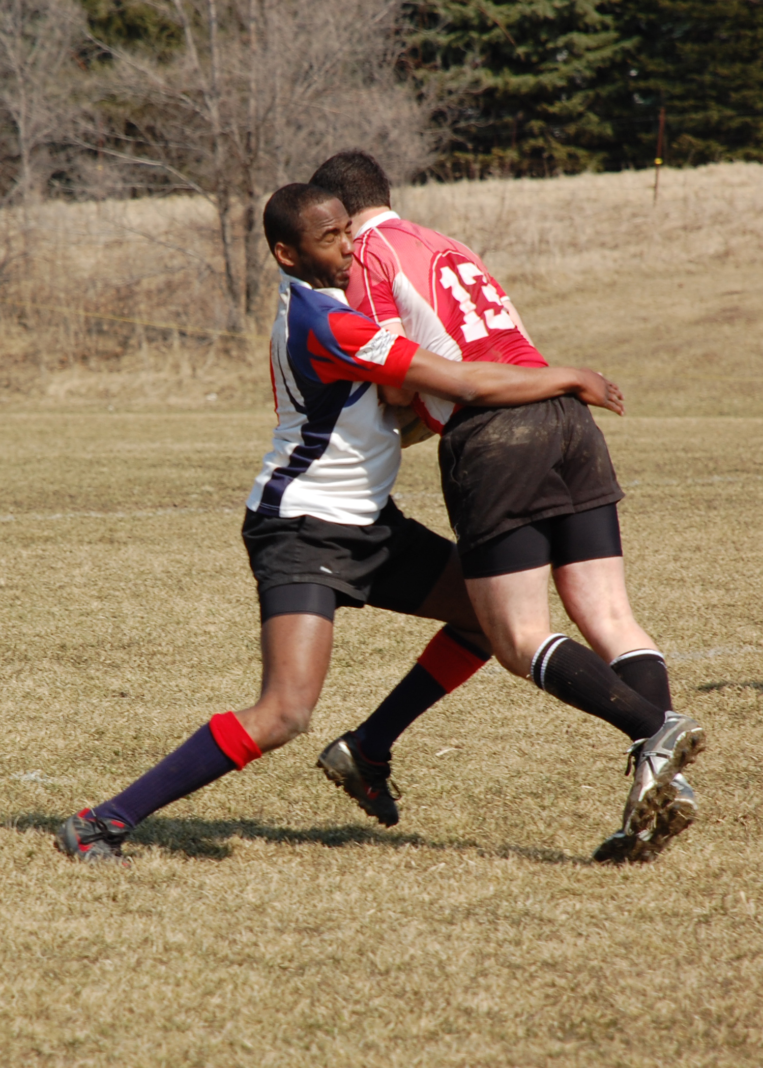 two people are on a field playing with a soccer ball