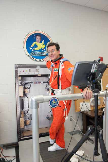 a man in an orange space suit is smiling for the cameraman