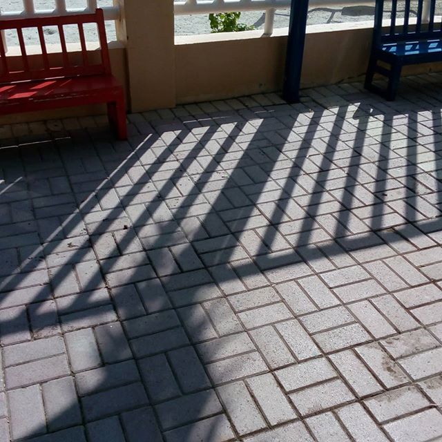 the shadow of benches on the walkway looks like it's being made