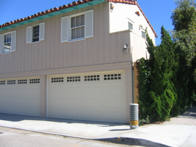 a beige home with white garage doors and a chimney