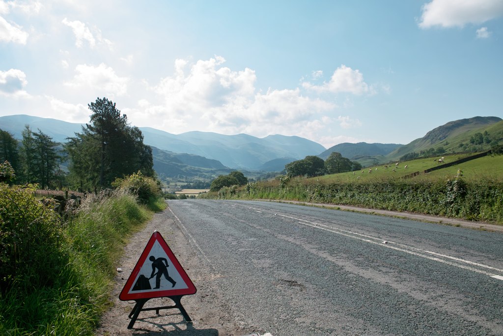 the pedestrian crossing sign on the side of the road