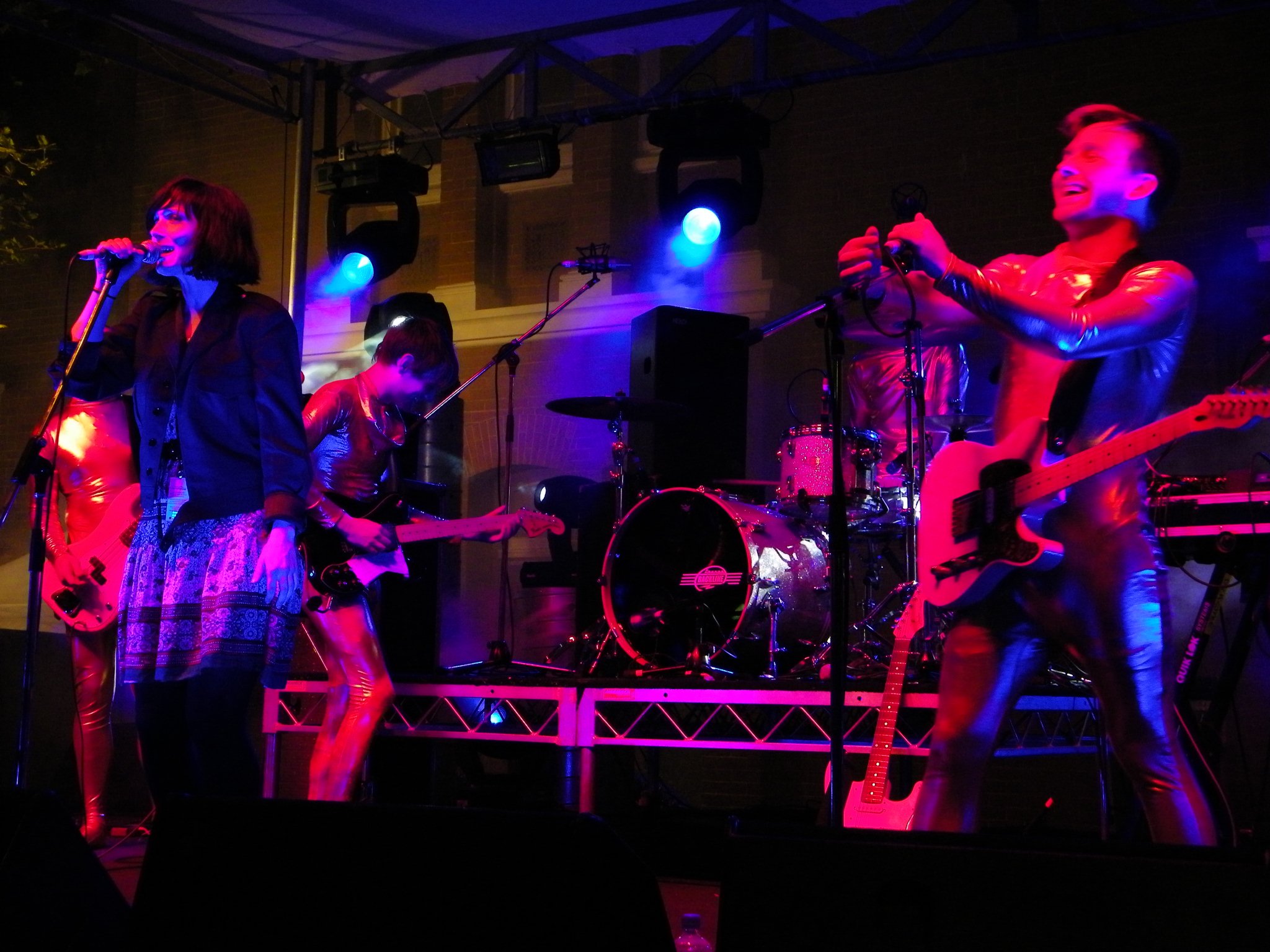 a band playing and singing on stage at a music event