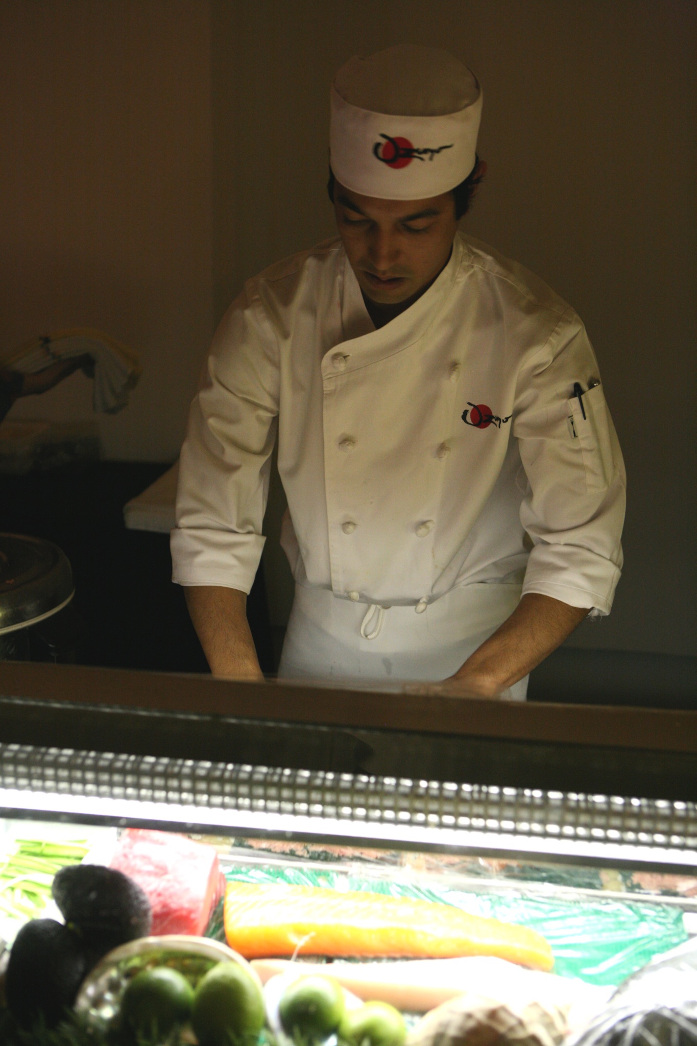 a chef standing in front of a table with veggies