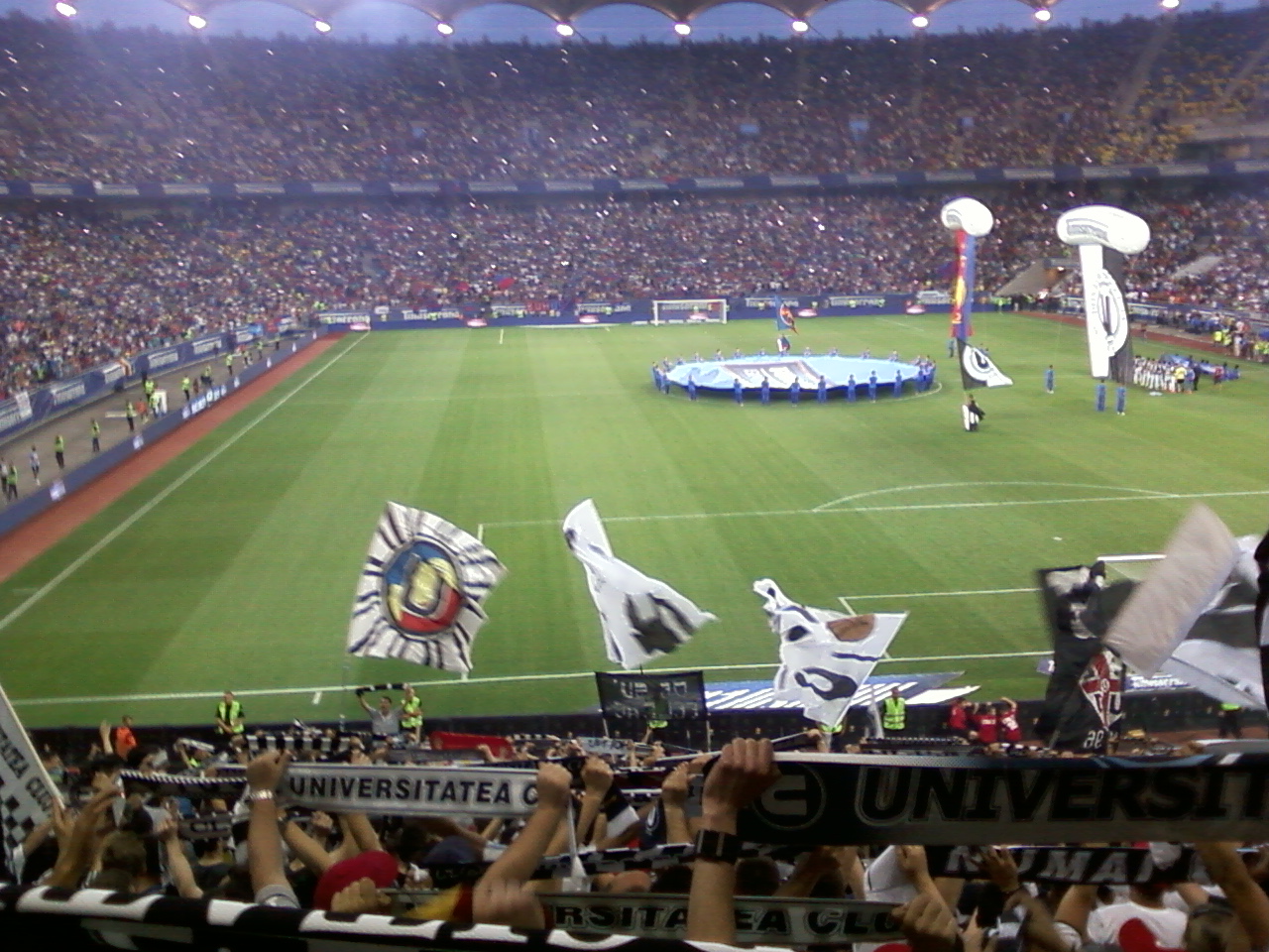 a stadium filled with fans, some holding up flags