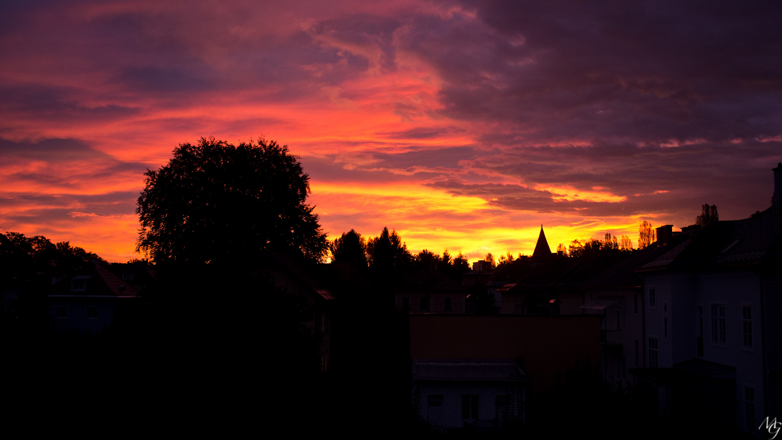 the sky is pink and orange in a city