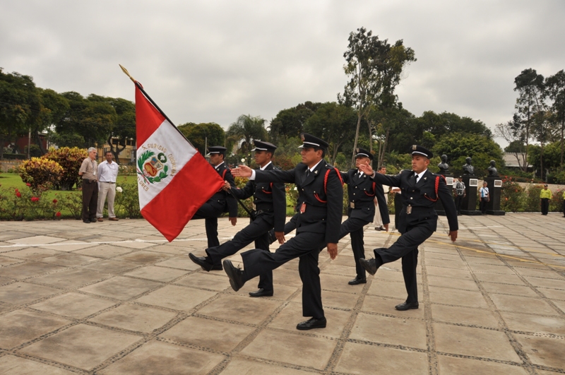 an outdoor performance featuring men in suits holding a flag