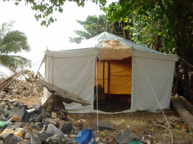 a white tent set up on top of a pile of rubble