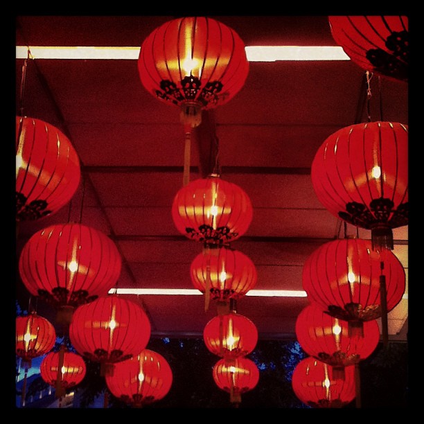many red lanterns hanging from a dark ceiling