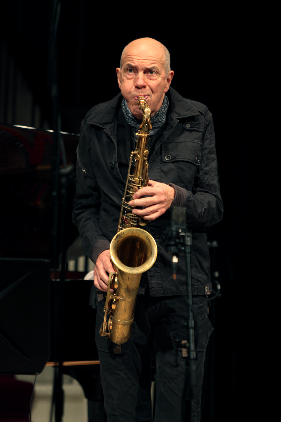 a man in black jacket playing a saxophone