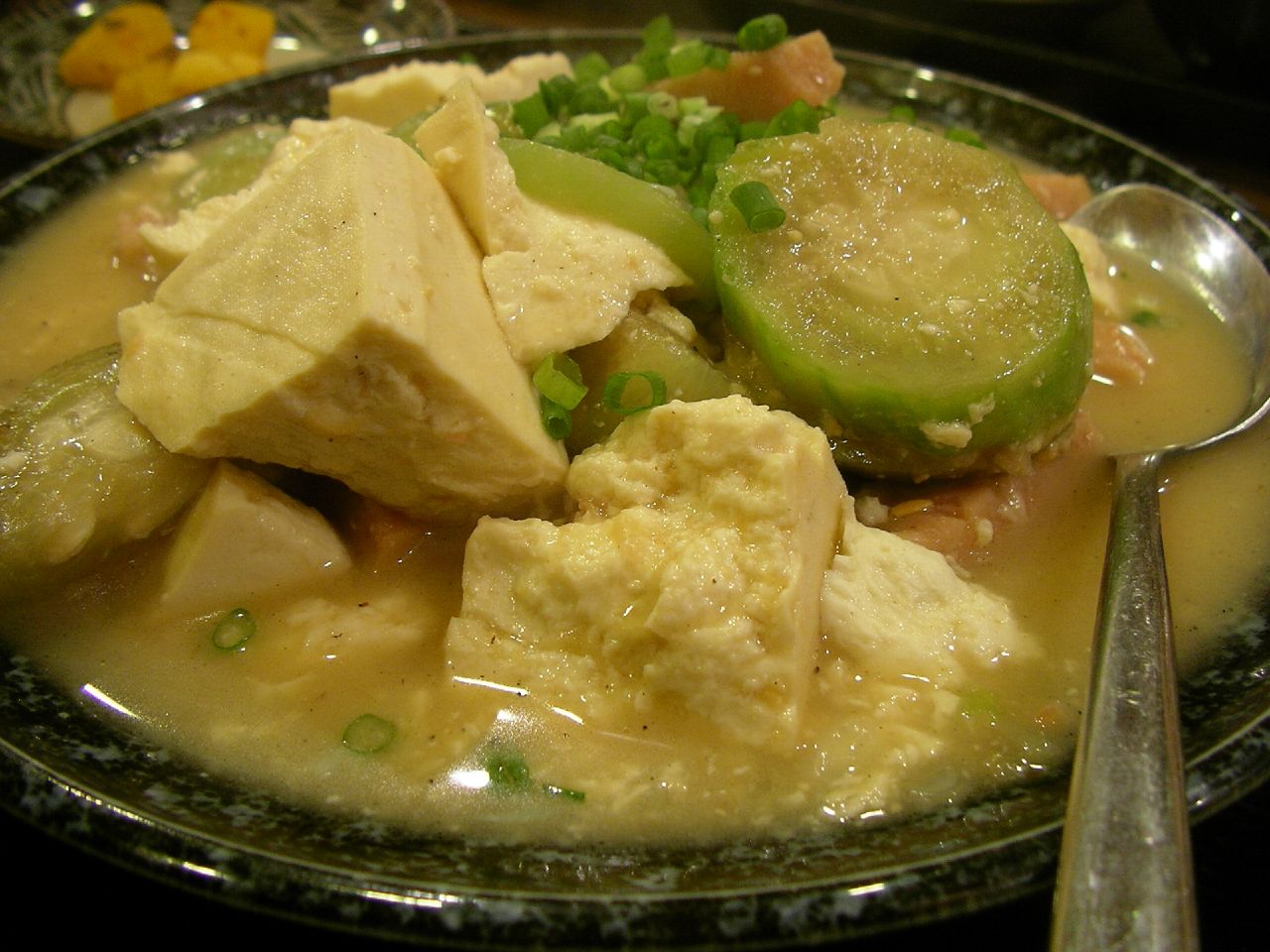 a bowl of tofu and vegetables with sauce