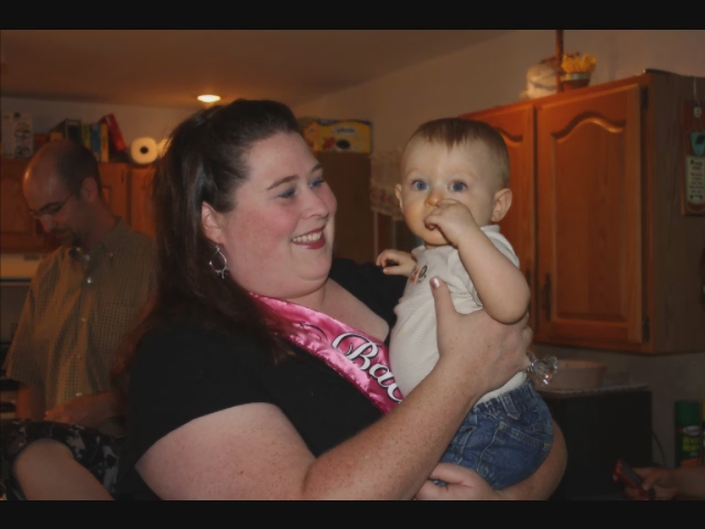 a woman holds a baby wearing a pink bandana