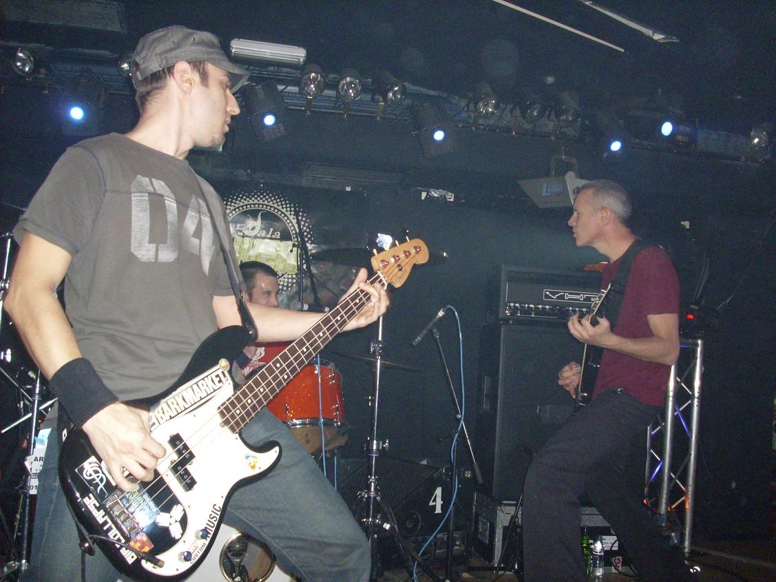 two men are playing guitars in front of microphones