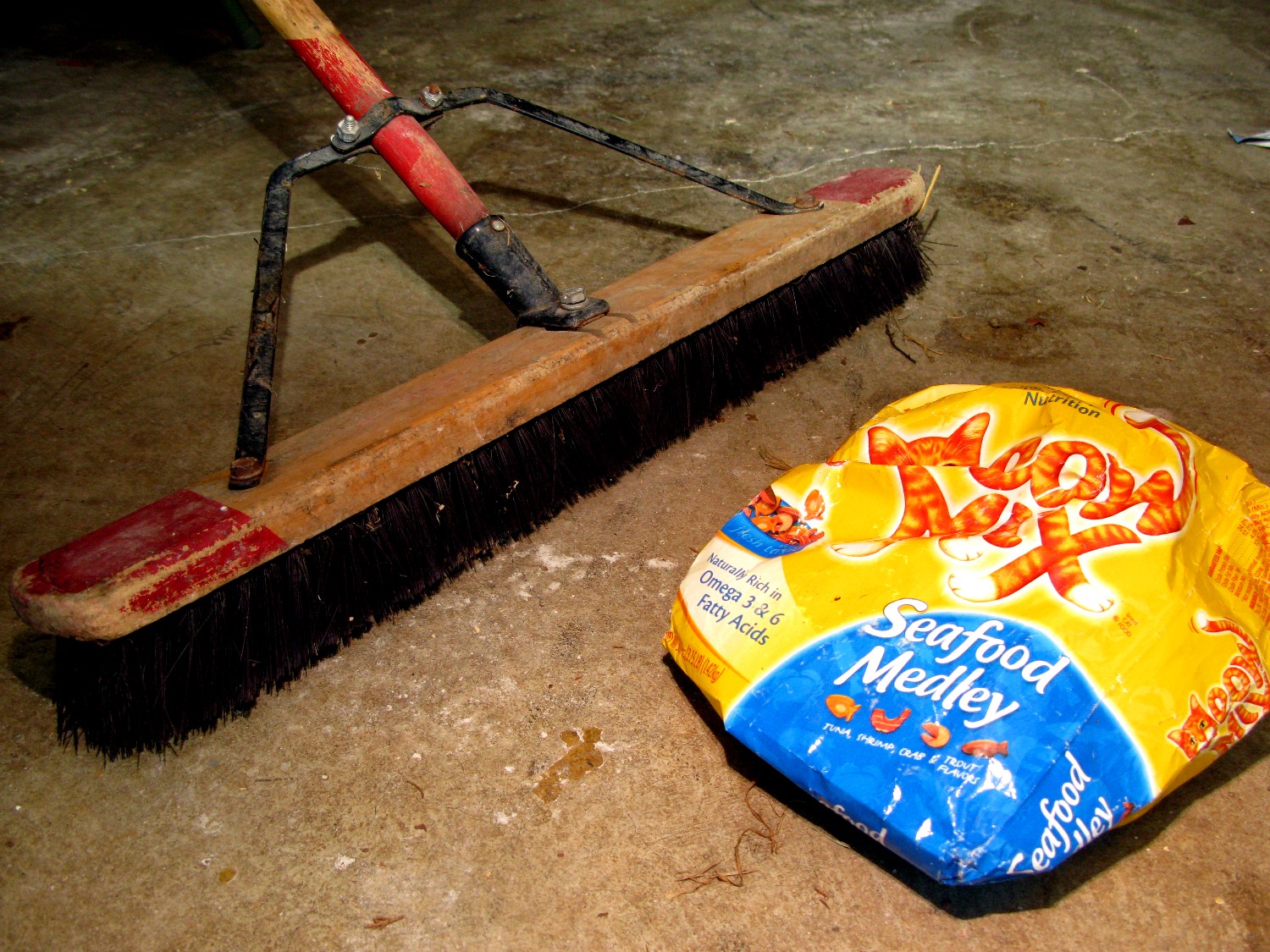 a brush and a container of food laying on a floor