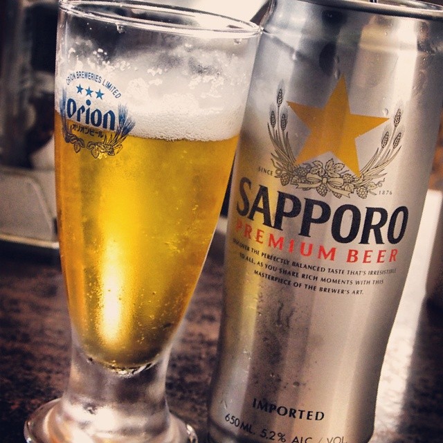 a beer next to a can of saporo