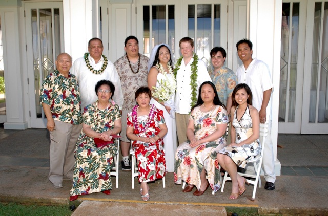 a group po of some people in hawaiian attire posing for a picture