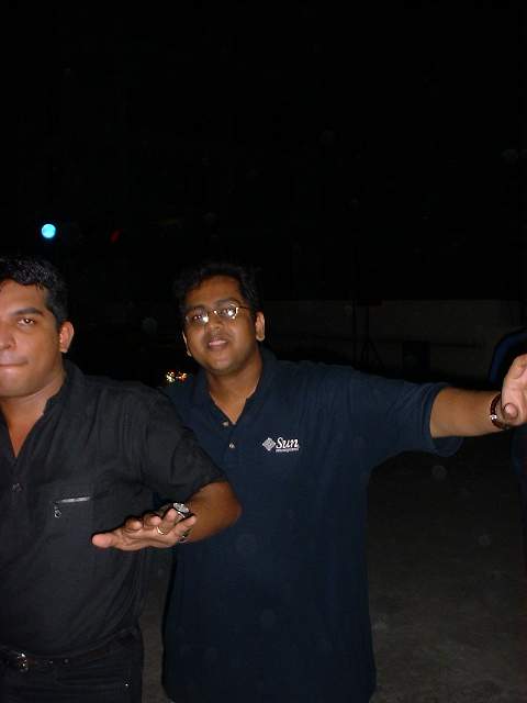 two men are posing for a po at night