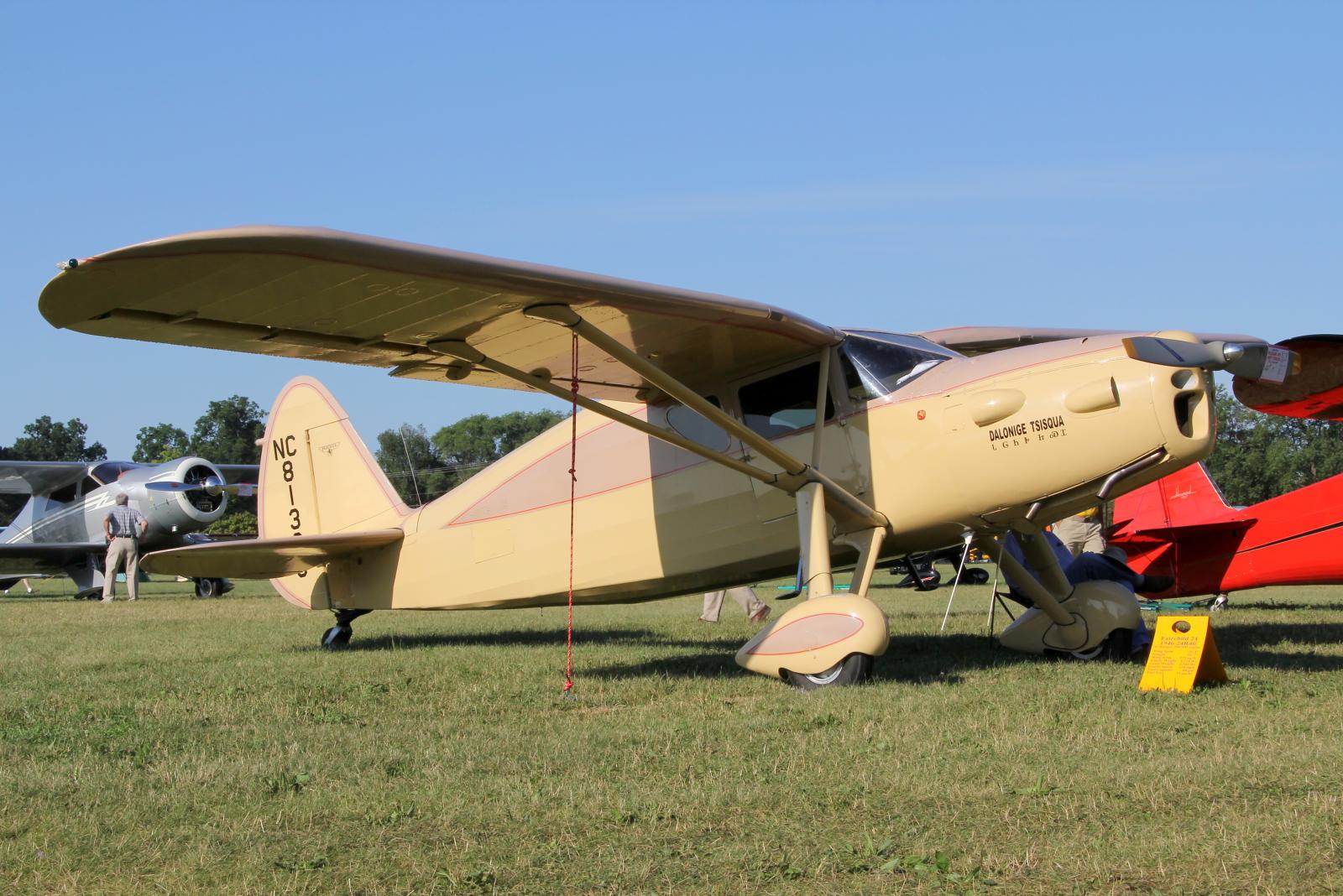 a red and a yellow plane in an open grassy field